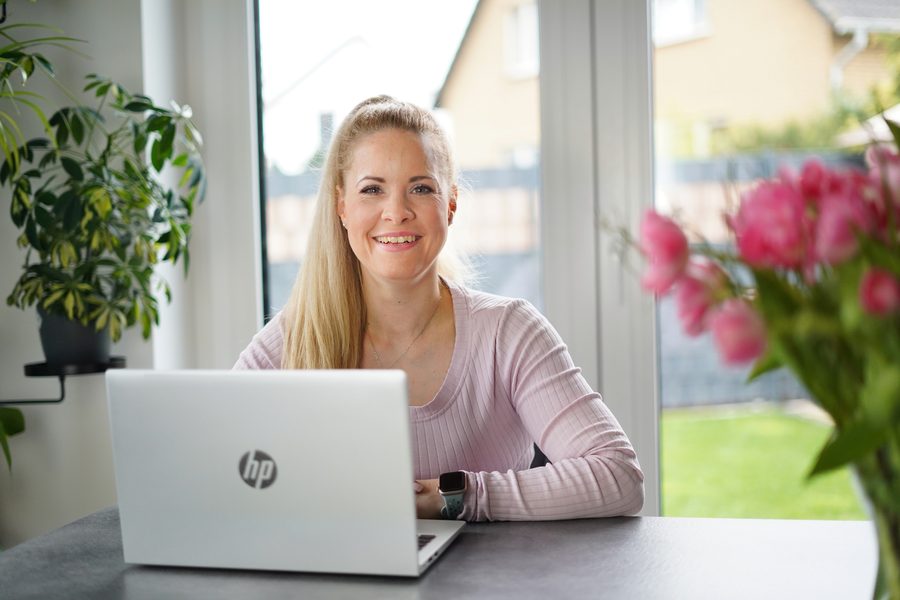 Josephine Fröhlich lacht während einer Online-Beratung am Laptop